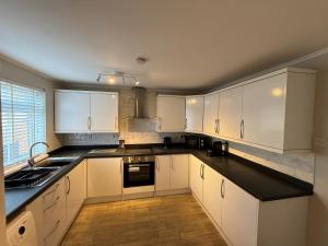 a kitchen with white cabinets and a black counter top at Donvale Road, Washington in Washington