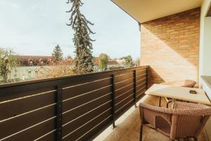 a balcony with a table and chairs and a fence at Ady54 in Tata