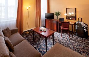 Chateau Monty Spa Resort في ماريانسكي لازني: غرفة معيشة مع أريكة ومكتب في غرفة الفندق