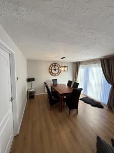 a dining room with a table and chairs and a clock at Donvale Road, Washington in Washington +4 photos