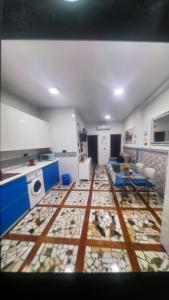 sala de estar con cocina con mesa y suelo en La fragua, en Granada