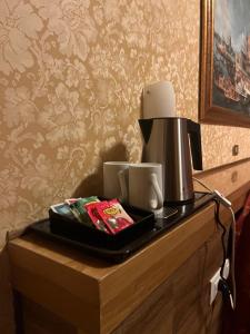 a coffee maker and two cups on a table at Hotel Al Sole in Preganziol