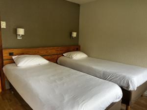 two beds in a room with white sheets at Campanile Dax - Saint-Paul-Les-Dax in Saint-Paul-lès-Dax