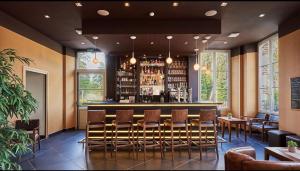 Un bar en un restaurante con sillas y una barra. en Appart Hôtel 3* dans une résidence de tourisme, en Le Mée-sur-Seine