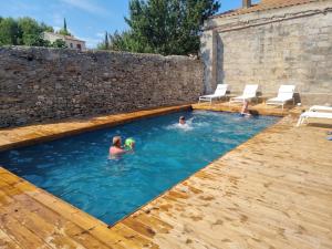 a group of people swimming in a swimming pool at Les 3 Platanes in Conilhac-Corbières