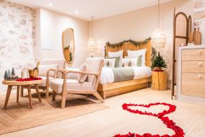 a bedroom with a bed and a chair and a table at La Parenthèse Grassoise-Votre échappée romantique in Grasse