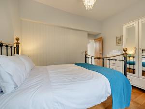 a bedroom with a large white bed and a chandelier at 1 bed property in Shaftesbury 46774 in Bourton