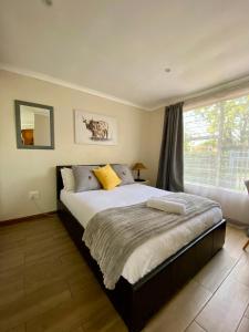 Un dormitorio con una cama grande y una ventana. en Cottage on Keurboom, en Midrand