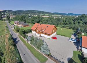 eine Luftansicht eines großen Hauses mit Auffahrt in der Unterkunft Pension Jitka in Šimonovice