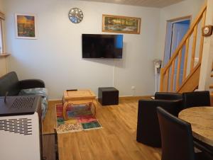 a living room with a table and a tv on the wall at Maison de ville avec jardin-Rêve à Rixheim! in Rixheim