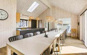 una grande sala da pranzo con un lungo tavolo e un orologio di Cozy Home In Vejby With Sauna a Vejby