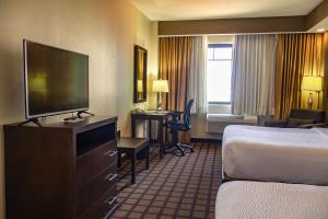 a hotel room with a bed and a flat screen tv at Best Western PREMIER Monterrey Aeropuerto in Monterrey