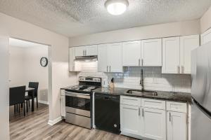 a kitchen with white cabinets and a stove top oven at Crest At East Cobb 1812 Comfort, Spacious 2bd 2bt in Marietta