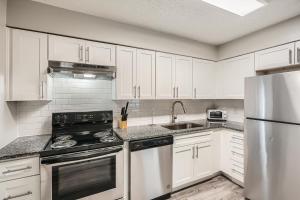 a kitchen with white cabinets and a stainless steel appliances at Crest At East Cobb1820e Comfort, Spacious 2bd 2bt in Marietta +7 photos