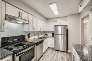 a kitchen with white cabinets and a stainless steel refrigerator at Crest At East Cobb1820e Comfort, Spacious 2bd 2bt in Marietta