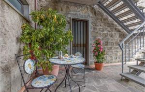 a table and chairs on a patio with plants at Awesome Home In Macchino With Kitchen in Marliana