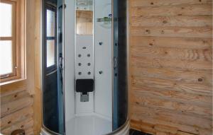 a shower in a room with a wooden wall at Holiday Home Brombærvej Xi in Lem