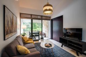 a living room with a couch and a flat screen tv at CR MARIPOSA RENTALS Mountain view near pool in Santa Ana
