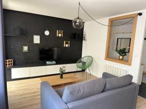 a living room with a couch and a television at Le Forum - HYPER centre - PARKING in Reims