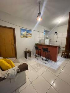 a living room with a couch and a kitchen at Flat Doce Jeri in Jericoacoara +23 photos