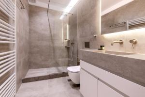 a bathroom with a sink and a toilet and a shower at Phaedrus Living Athens Luxury Residences Ivory in Athens +2 photos