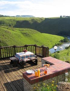 a wooden deck with a table and a picnic table at Birches Cottage & the Willows Garden Room in Underberg