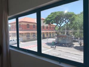 een raam met uitzicht op een stadsstraat bij Hotel Pousada Liberdade in Pindamonhangaba