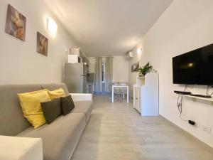a living room with a couch and a flat screen tv at ALLA CASA ROSA RAPALLO, Peaceful Multiple Apartment Surrounded by Greenery with Free Parking, WiFi & Air Conditioning in Rapallo