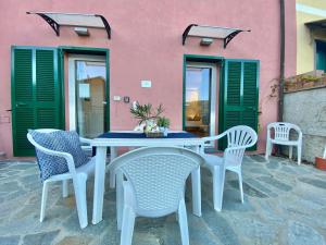 a table and chairs in front of a pink building at ALLA CASA ROSA RAPALLO, Peaceful Multiple Apartment Surrounded by Greenery with Free Parking, WiFi & Air Conditioning in Rapallo