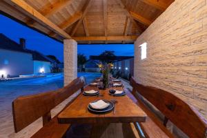 une table en bois avec des assiettes de nourriture dessus dans l'établissement Atraktivna Villa Lana s dva bazena, à Dušić