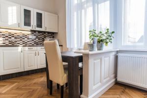 a kitchen with a wooden table and white cabinets at All In Apartman in Budapest