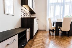 a kitchen and dining room with a table and chairs at All In Apartman in Budapest