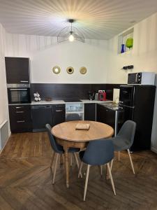 a kitchen with a wooden table and chairs at Gîte Le Saint Père in Avallon