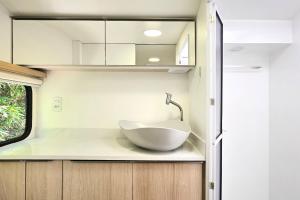 a bathroom with a white bowl sink on a counter at Trailer Experience - Moradas Campeche Pé na Areia in Florianópolis +29 photos