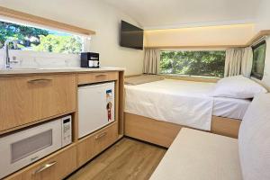 a small bedroom with a bed and a sink at Trailer Experience - Moradas Campeche Pé na Areia in Florianópolis