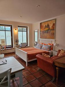 ein Schlafzimmer mit großem Bett und Couch in der Unterkunft Backsteinparadies in Lüneburg