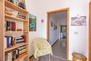 a room with a book shelf and a chair at La Terrazza sul Forno - Goelba in Portoferraio