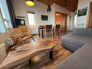 un soggiorno con tavolo in legno e divano di Blue View Cabin 4A With private hot tub a Reykholt