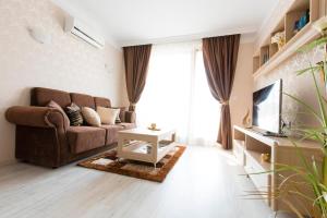 a living room with a couch and a tv at Harmony Suites - Dream Island in Sunny Beach