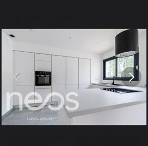 a kitchen with white cabinets and a stove top oven at Maison in Belleneuve