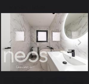 a white bathroom with a sink and a mirror at Maison in Belleneuve