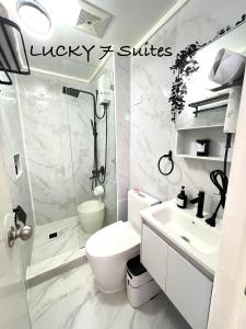 a bathroom with a toilet and a shower and a sink at Lucky 7 Suites in Manila +8 photos