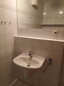ein Badezimmer mit einem weißen Waschbecken und einem Spiegel in der Unterkunft Villa Seewind Wohnung 9 in Dahme