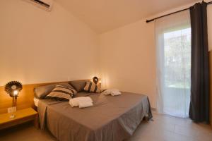 a bedroom with a bed with two towels on it at Residence in Costa Rei just 450 meters from the beach, apartments with air conditioning and outdoor private area in Costa Rei