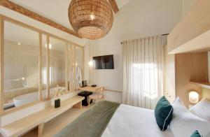 a bedroom with a bed and a bathroom with a tub at La Maison Gaïa Hôtel & Spa in Torreilles