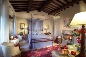 a bedroom with a canopy bed and a fireplace at Borgo Della Marmotta in Spoleto