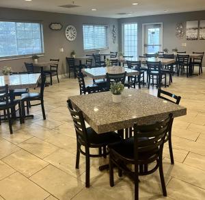 a dining room with tables and chairs in a restaurant at GrandStay Hotel & Suites Becker in Becker