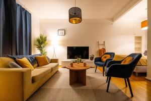 a living room with a couch and chairs and a tv at Prime City Escape 45 Square Meters in Helsinki +13 photos