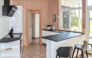 a kitchen with a black counter top and chairs at Holiday Home Musvãgevej Ã Lbãk X in Ålbæk