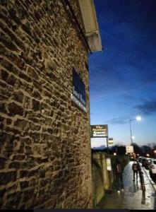 a brick building with a sign on the side of it at Station Guesthouse - Self entry via keypad inc parking in Lancaster